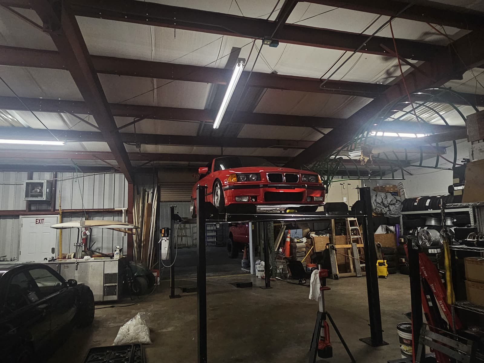 Red BMW M3 up on the lift in the bay