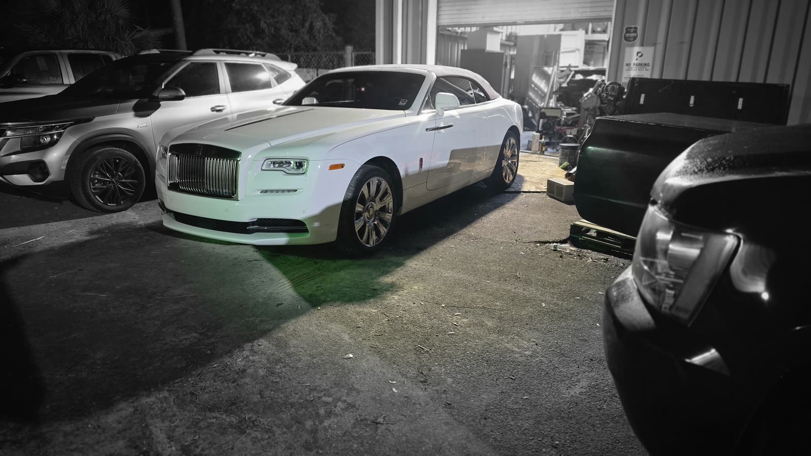 Rolls-Royce and trucks in the lot