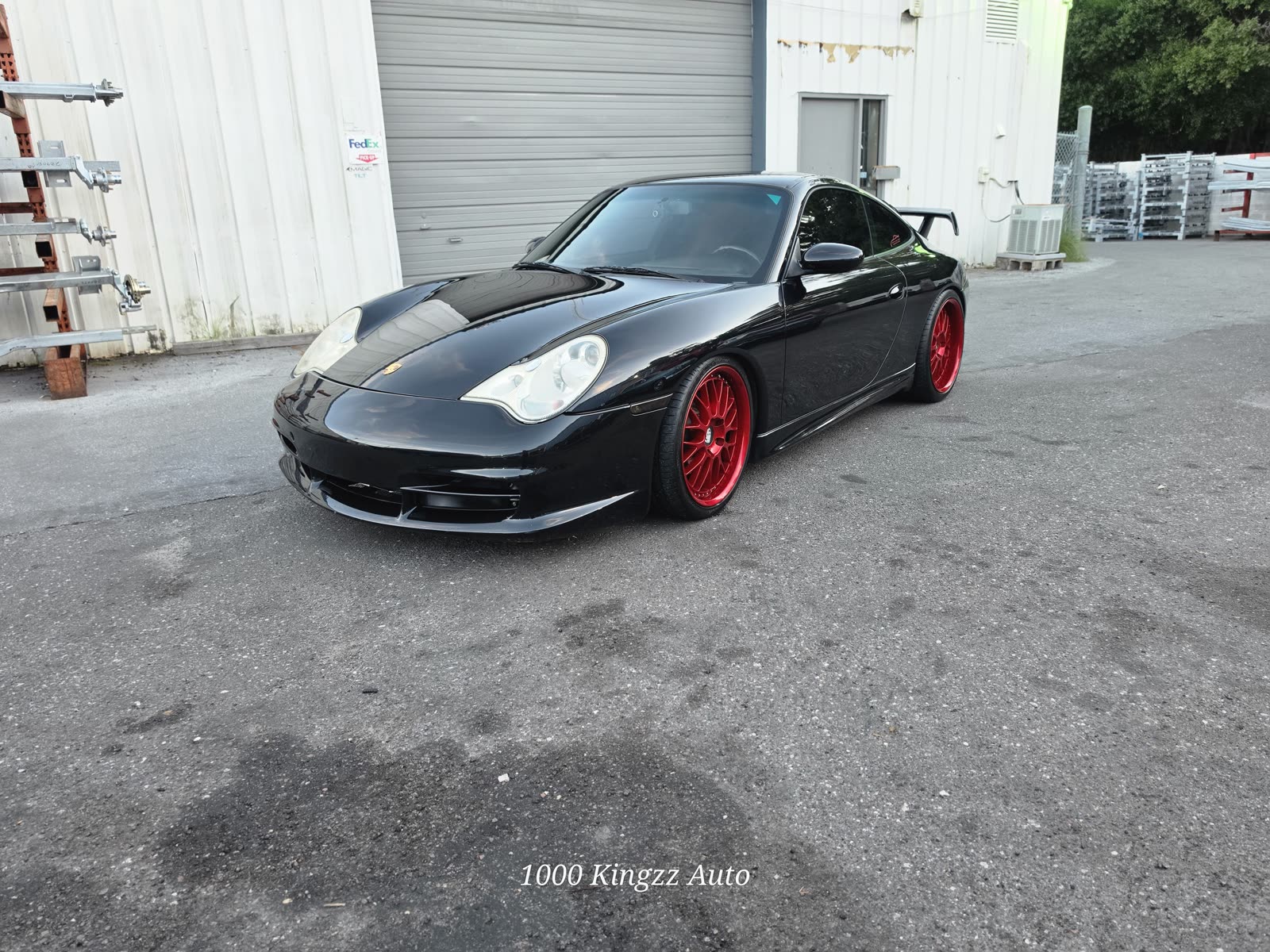 Porsche 911 GT3 on red wheels outside the shop