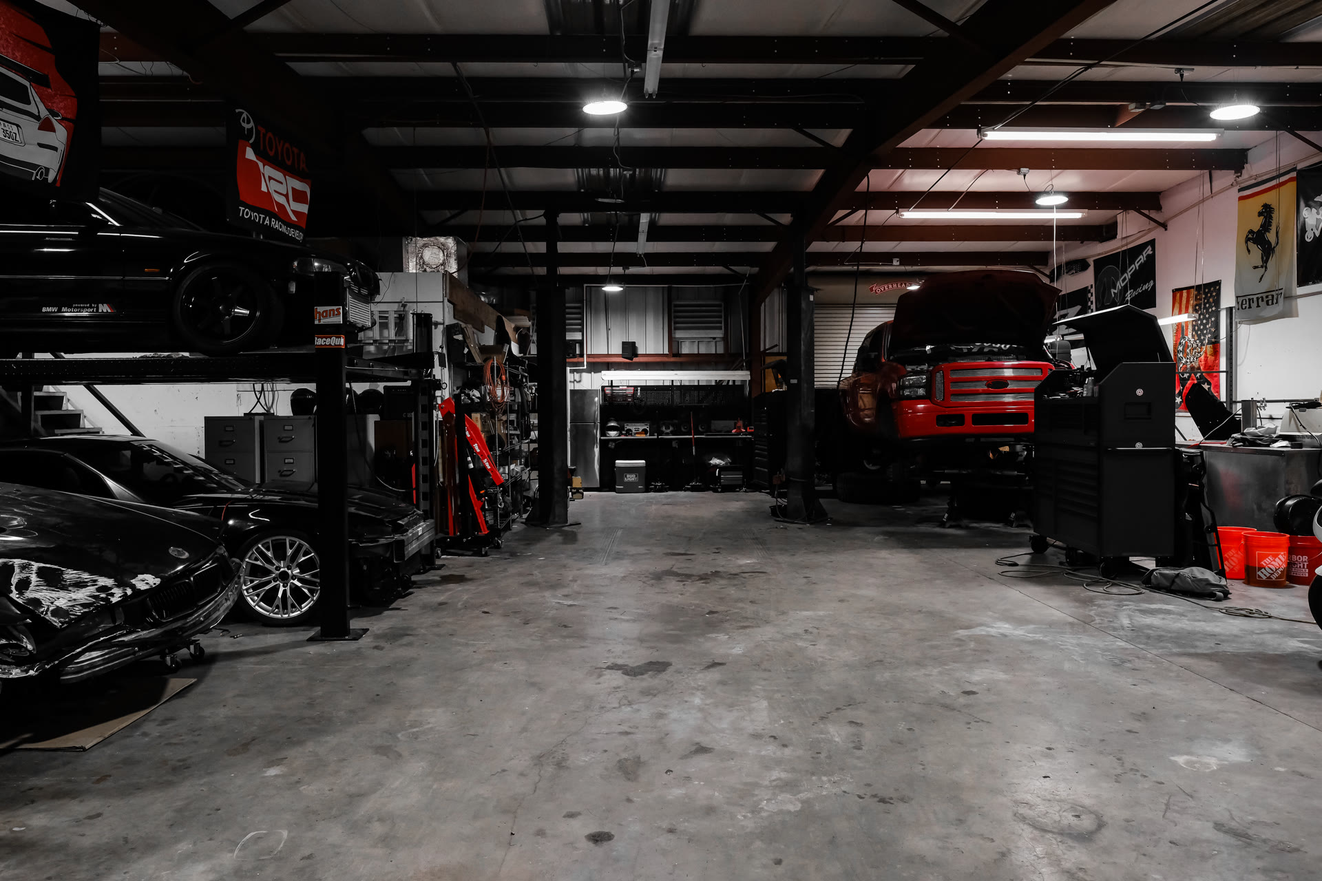 The 1000 Kingzz Auto shop floor with a work truck in the bay, hood up