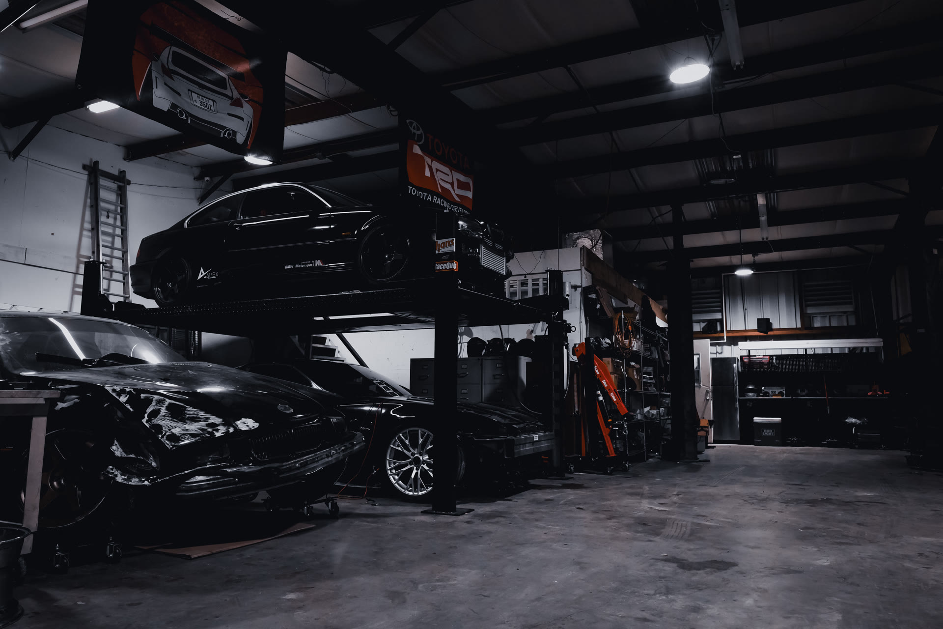 Four-post lift with project cars at 1000 Kingzz Auto in Clearwater